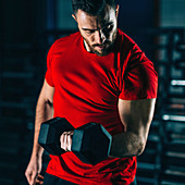 Young man exercising with dumbbells