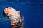 Woman surfacing from underwater