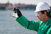 Inspector with sample of polluted water