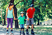 Family roller skating in park