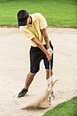 Golfer playing from bunker