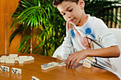Schoolboy playing dominoes