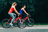 Women riding bikes together in a park