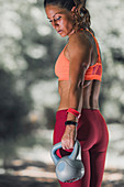 Woman exercising with kettlebell outdoors
