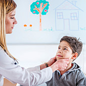 Paediatrician examining boy's glands