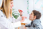 Paediatrician examining boy's throat