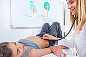 Paediatrician examining boy's abdomen