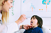 Paediatrician examining boy's throat