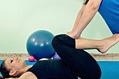 Physical therapist helping woman stretch