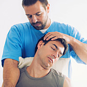 Physiotherapist stretching man's neck