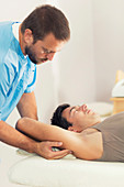 Physiotherapist stretching man's arm