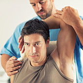 Physiotherapist stretching man's arm