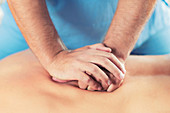 Physiotherapist massaging man's back