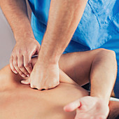 Physiotherapist massaging man's back