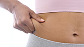 Woman pinching fat around waist