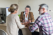 Doctor discussing with a couple during consultation