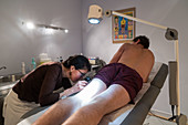 Dermatologist examining the skin of a patient