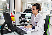 Lab technician examining cervico-vaginal smear