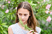 Young girl smelling rosemary