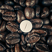 Caffeine supplement pill and coffee beans