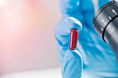 Scientist holding a red pill