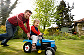 Father pushing son on tractor