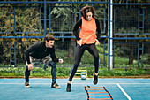 Young woman exercising with agility ladder