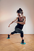 Woman exercising with sliding fitness discs