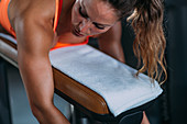 Female athlete using lying leg curl bench in the gym