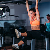 Female athlete doing pull-ups in the gym