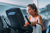 Woman exercising on cycling machine