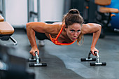 Female athlete doing push-ups in the gym