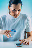 Woman using pulse oximeter and smart phone