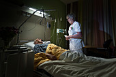 Nurse checking on patient on palliative care ward