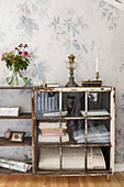 Vintage-style display case made from shelved and old window against floral wallpaper
