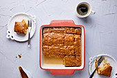 Tres Leches cake in baking tray, covered with caramel sauce and sprinkled with sea salt