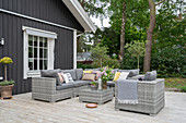 Pale grey seating on terrace outside wooden house