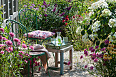 Stühle auf Kiesterrasse am Gartenhaus, Sonnenhut 'Butterfly Kisses' und Conetto 'Banana', Strauchhortensie