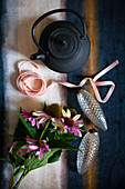 Black teapot, ribbons, glass, pine-cone Christmas-tree decorations and Echinaceas