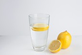 A glass of water with fresh lemon slices