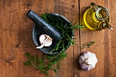 Mortar and pestle with garlic and herbs and olive oil