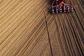 Aerial view of tractor sowing corn in field