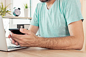 Freelancer using smart phone in home office