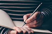 Left-handed woman writing diary