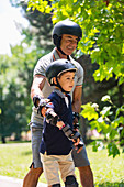 Grandfather teaching grandson to roller skate