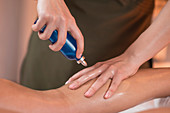 Physiotherapist applying massage oil