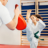 Taekwondo instructor working with girl