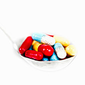 Spoonful of multicolored capsules