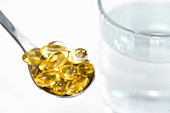 Vitamin E capsules and glass of water