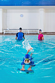 Boy having a swimming lesson with instructor